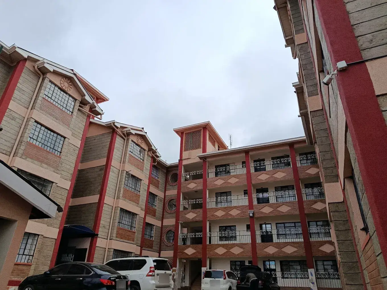 Multi-story residential building with red and beige facade