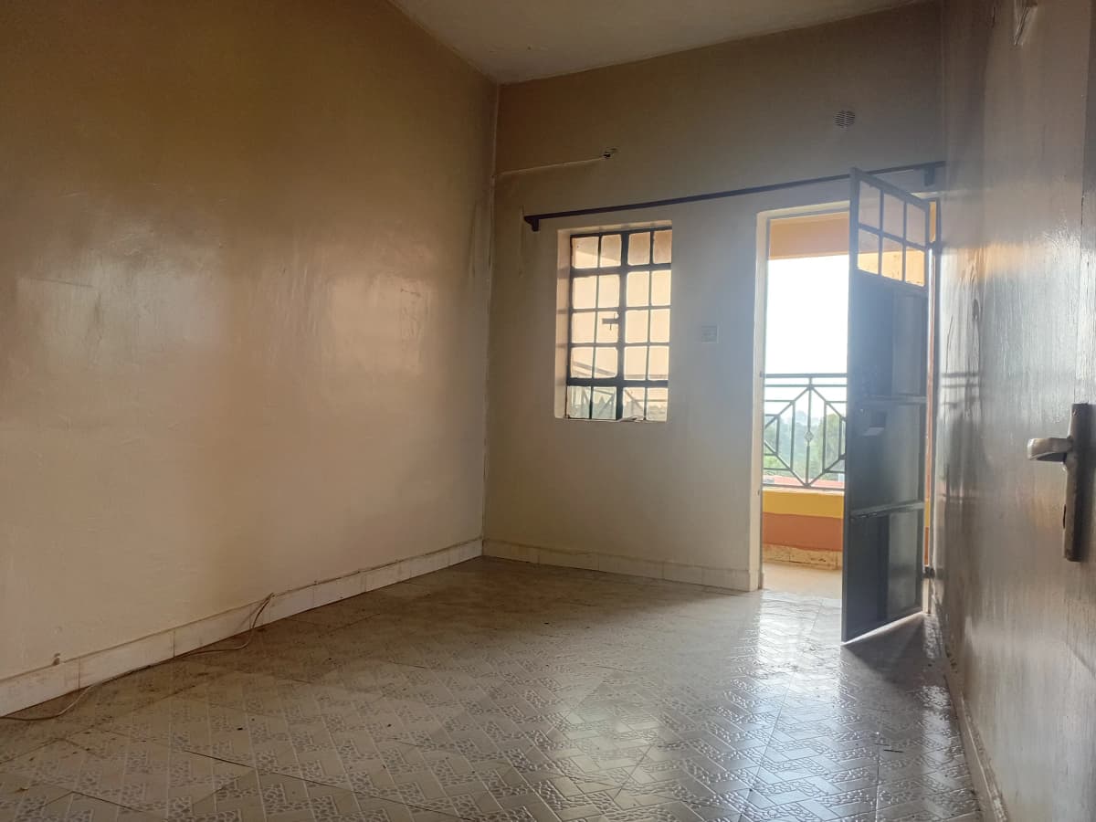 Empty bedroom with access to balcony overlooking landscape