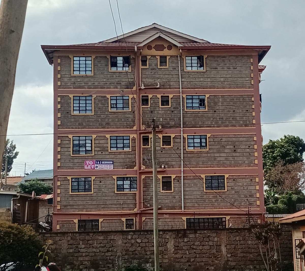 Four-story residential building with wooden shingle facade