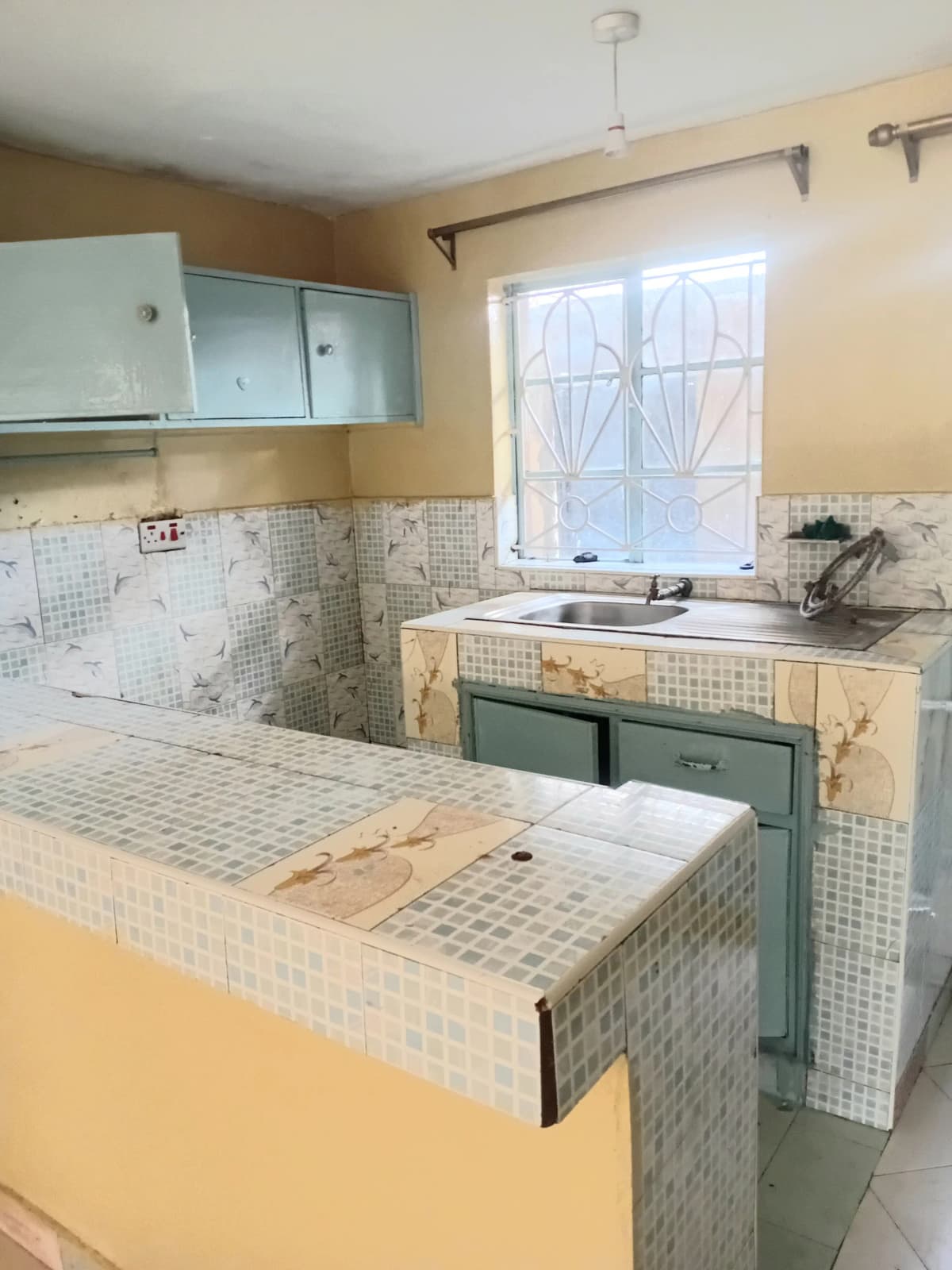 Vintage kitchen with tile countertops and green cabinetry