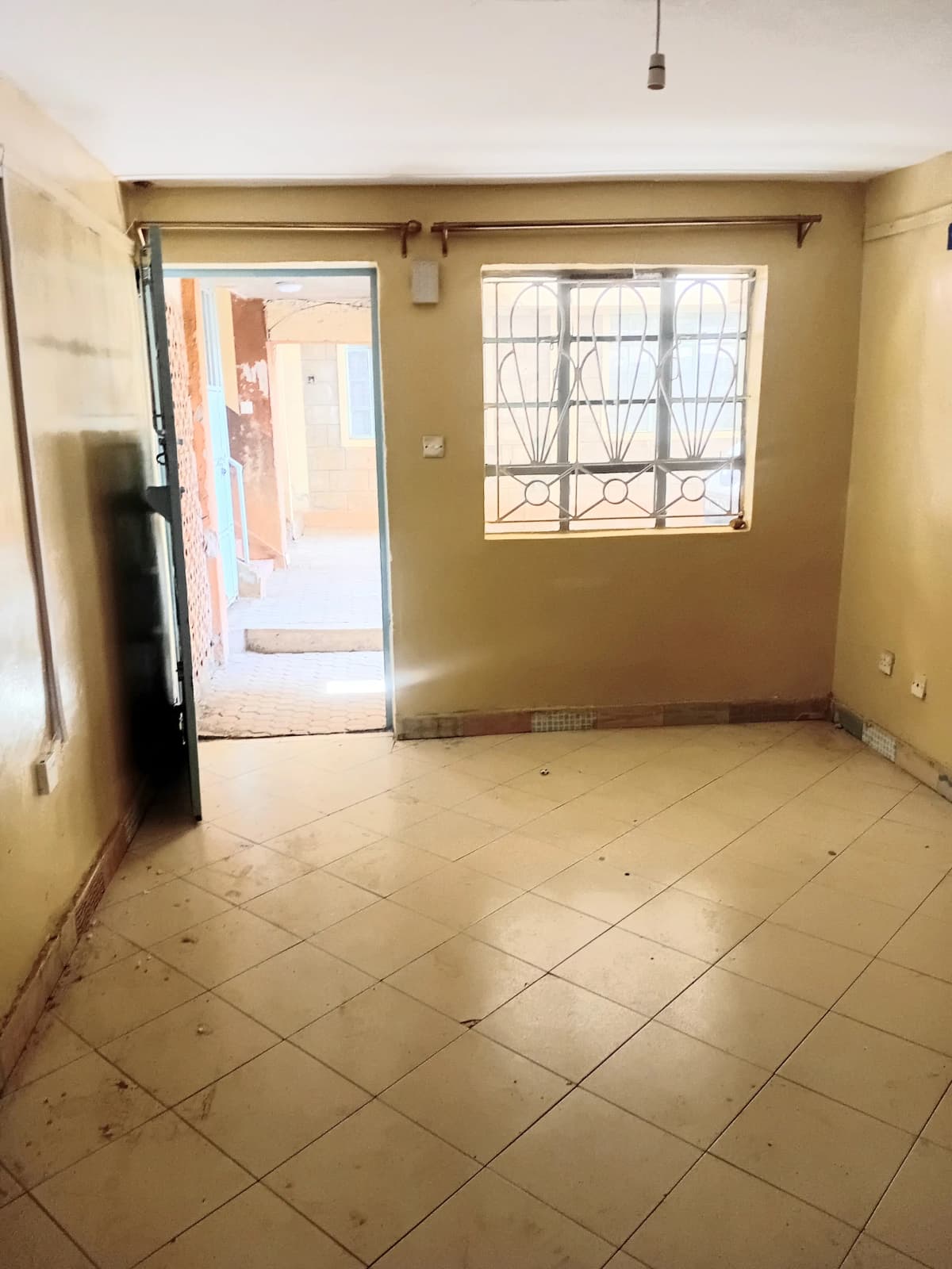 Bare living room with tiled floor and large window