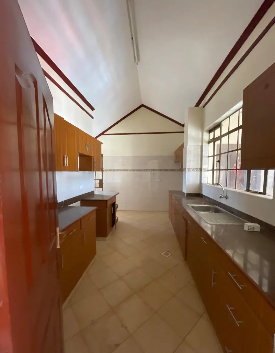 Spacious kitchen with wooden cabinetry and skylight ceiling