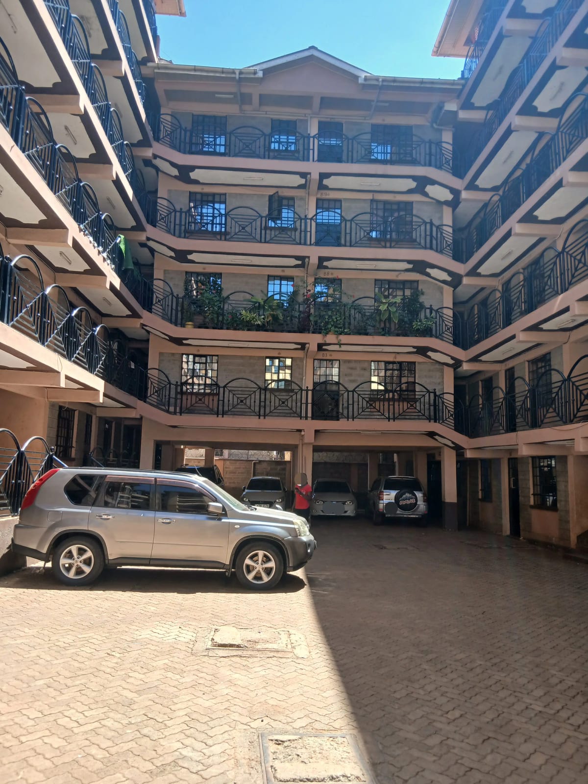 Multi-story residential compound with parking and balconies