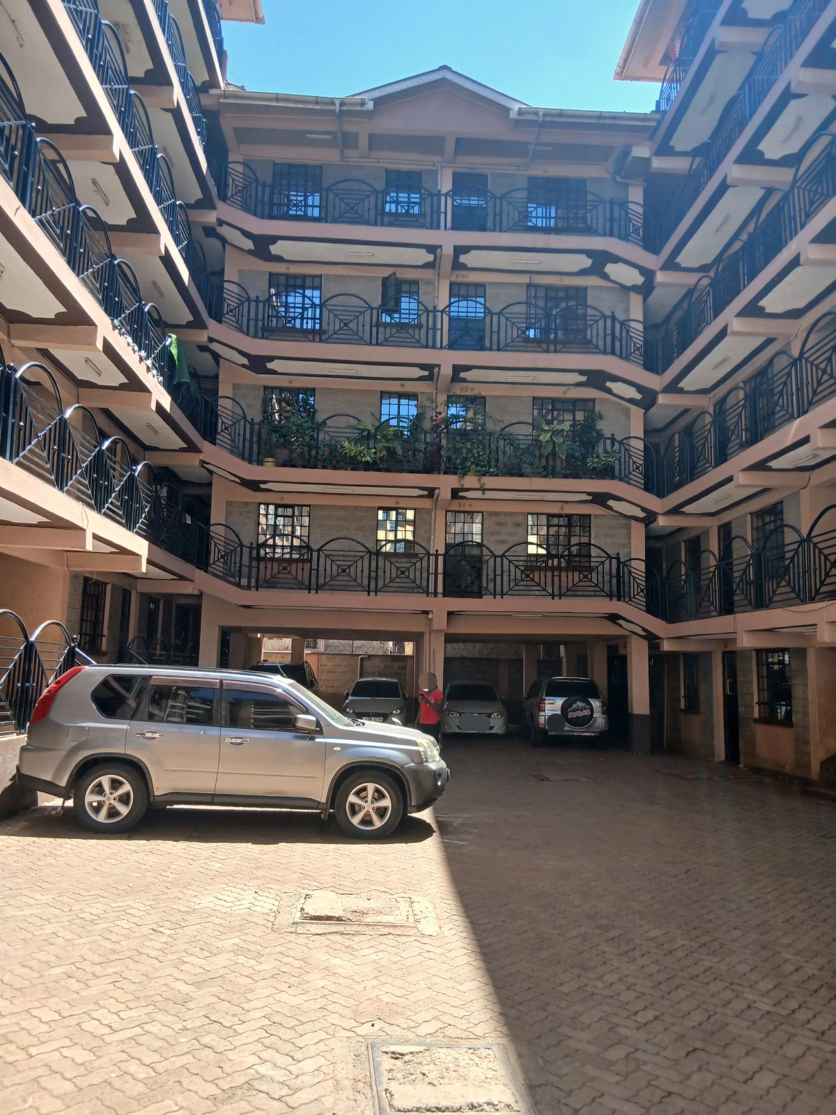 Multi-story residential compound with parking and balconies