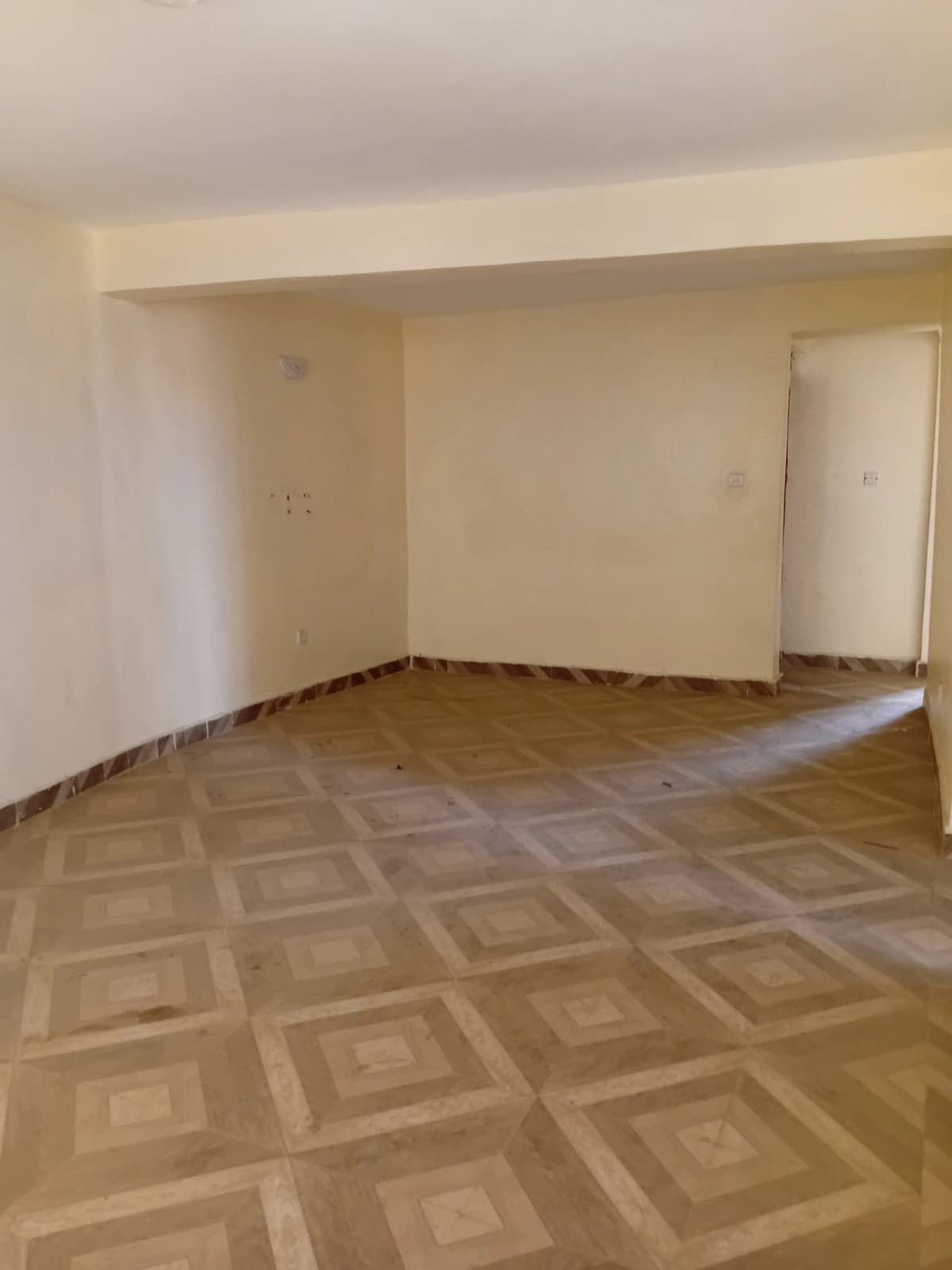 Spacious living room with geometric patterned wooden flooring