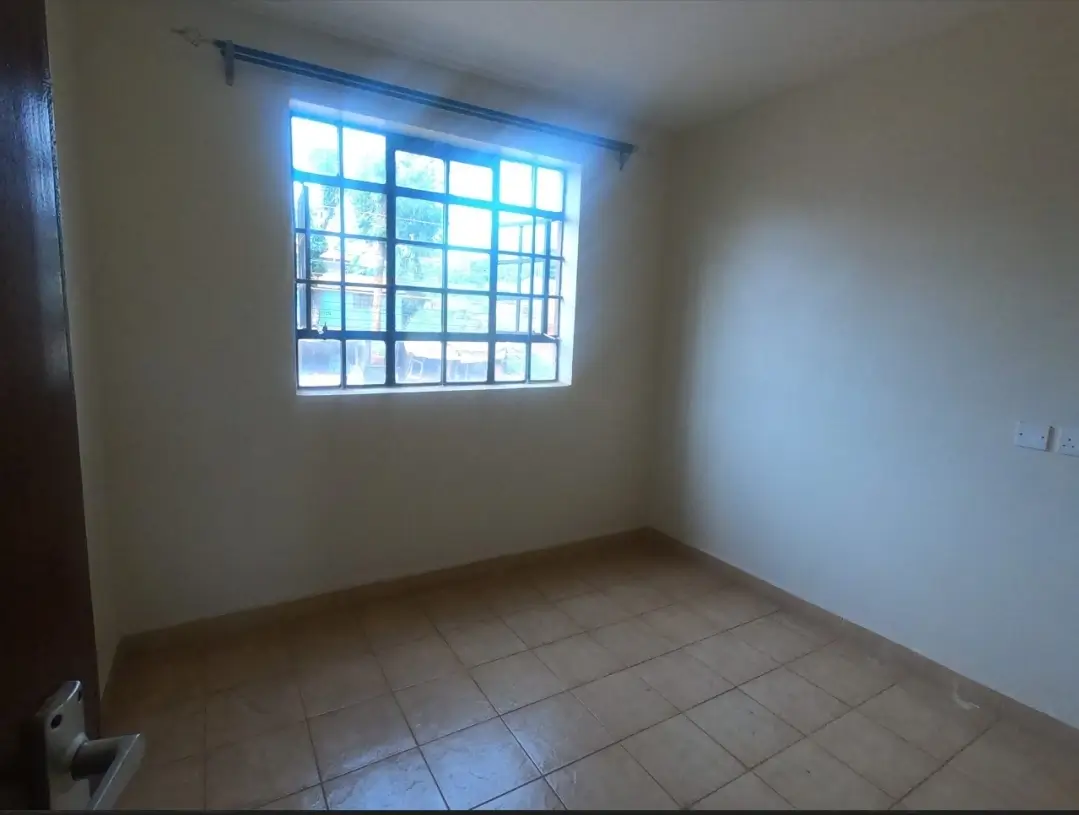 Bright bedroom with barred window and tiled flooring