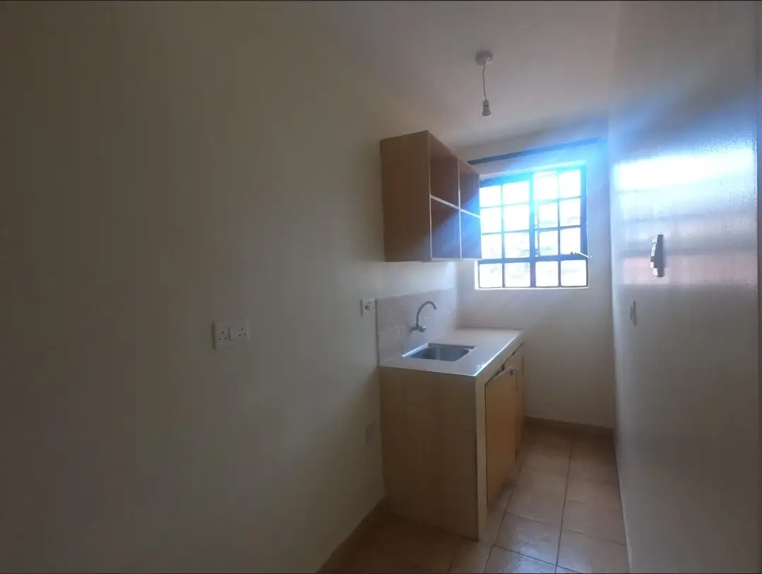 Compact kitchen with wooden cabinets and bright window
