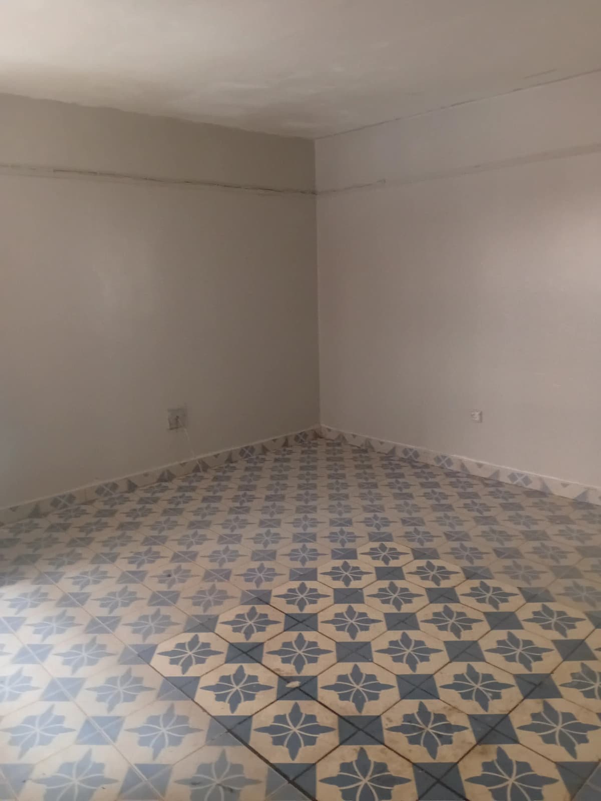 Empty bedroom with geometric patterned tile flooring