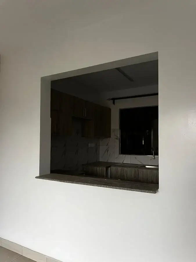 Kitchen pass-through window with dark cabinetry visible