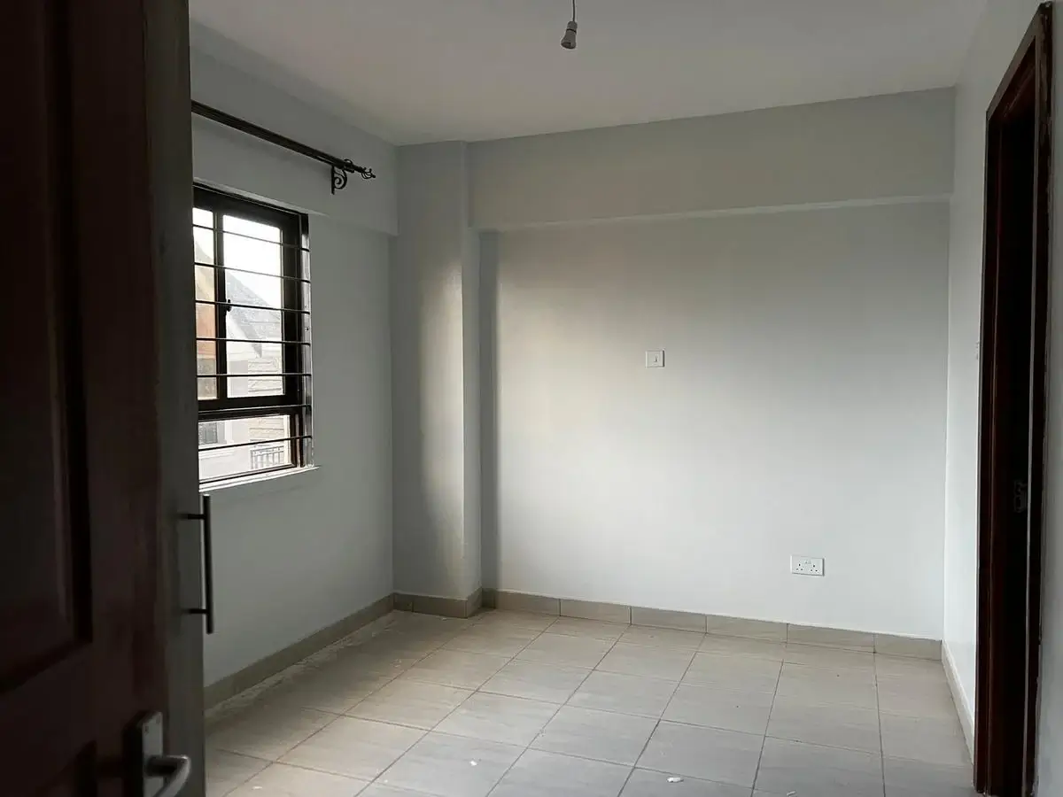 Unfurnished bedroom with tiled floor and natural light