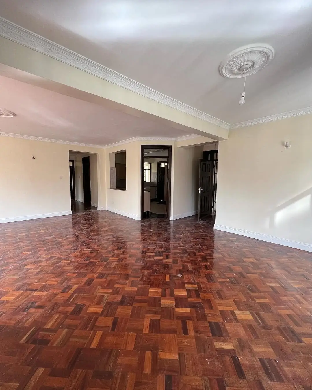 Spacious open-plan living area with herringbone wooden flooring