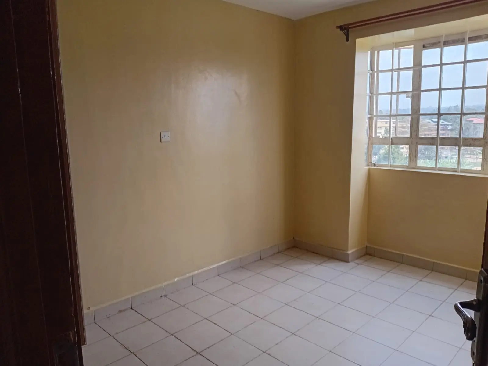 Spacious bedroom with tiled floor and large windows