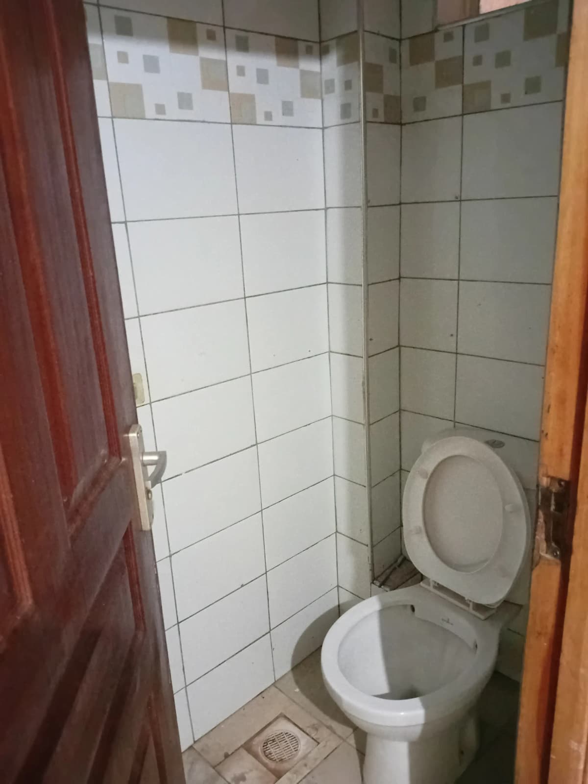Compact bathroom with toilet and tiled shower enclosure