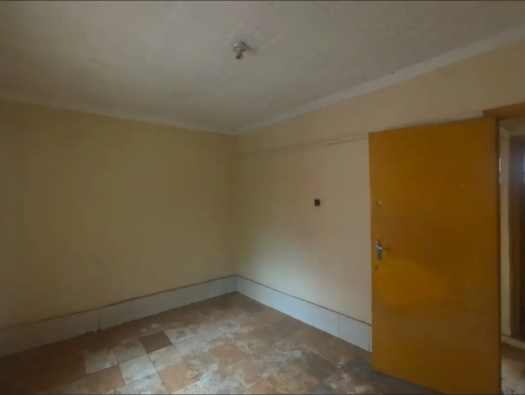 Empty bedroom with cream walls and wooden door entry
