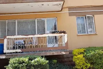 Covered balcony with white railings and yellow exterior walls