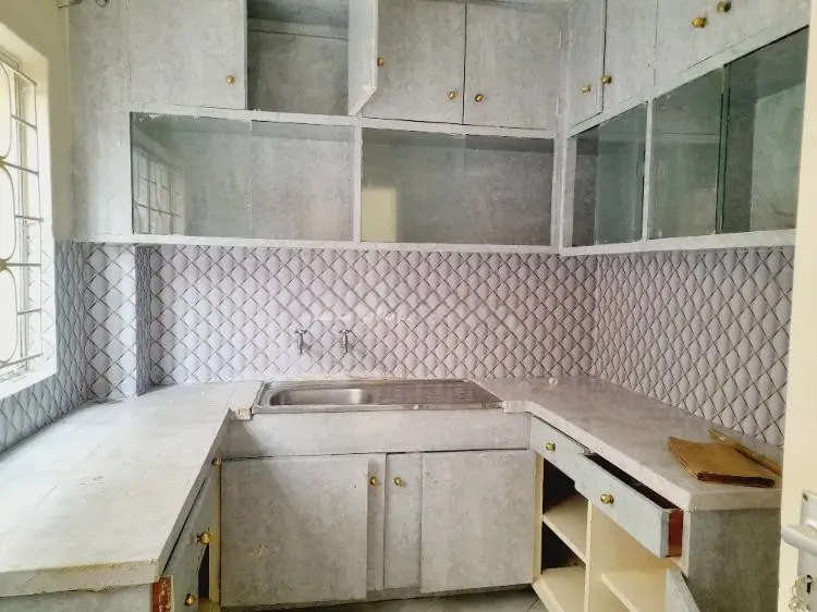 Compact kitchen with geometric tile backsplash and stainless steel sink