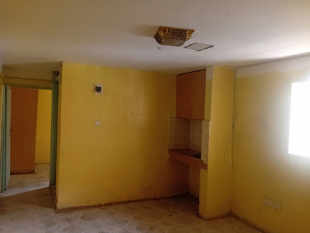 Empty living room with yellow walls and natural light