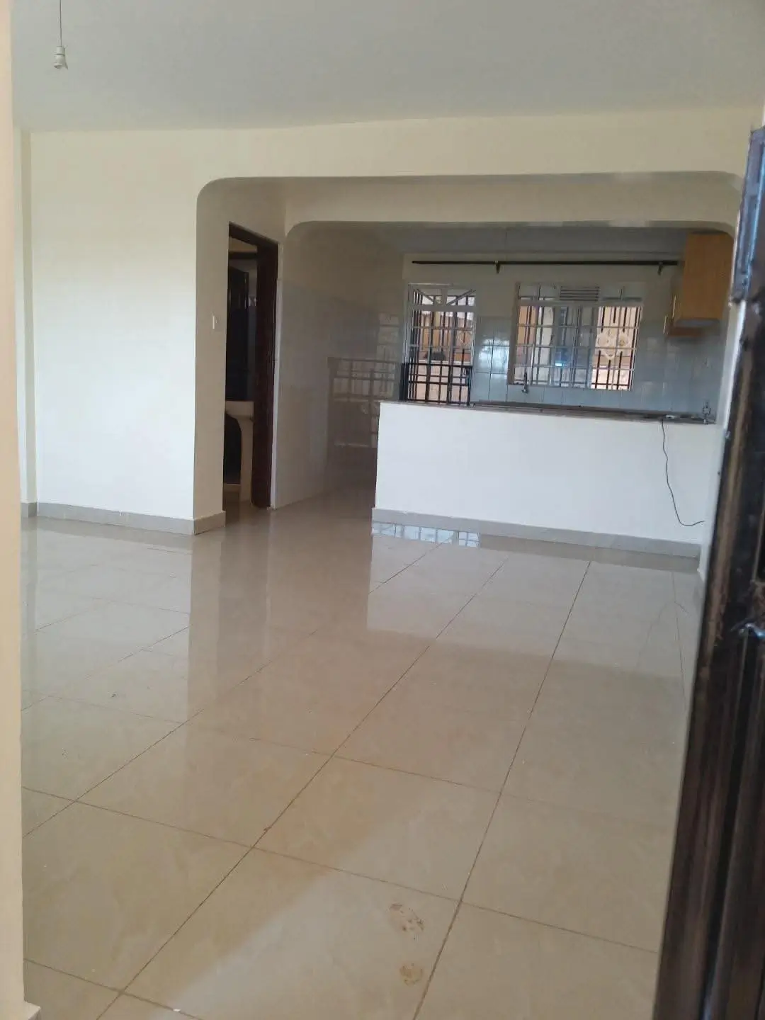 Open-plan living and kitchen area with polished tile flooring