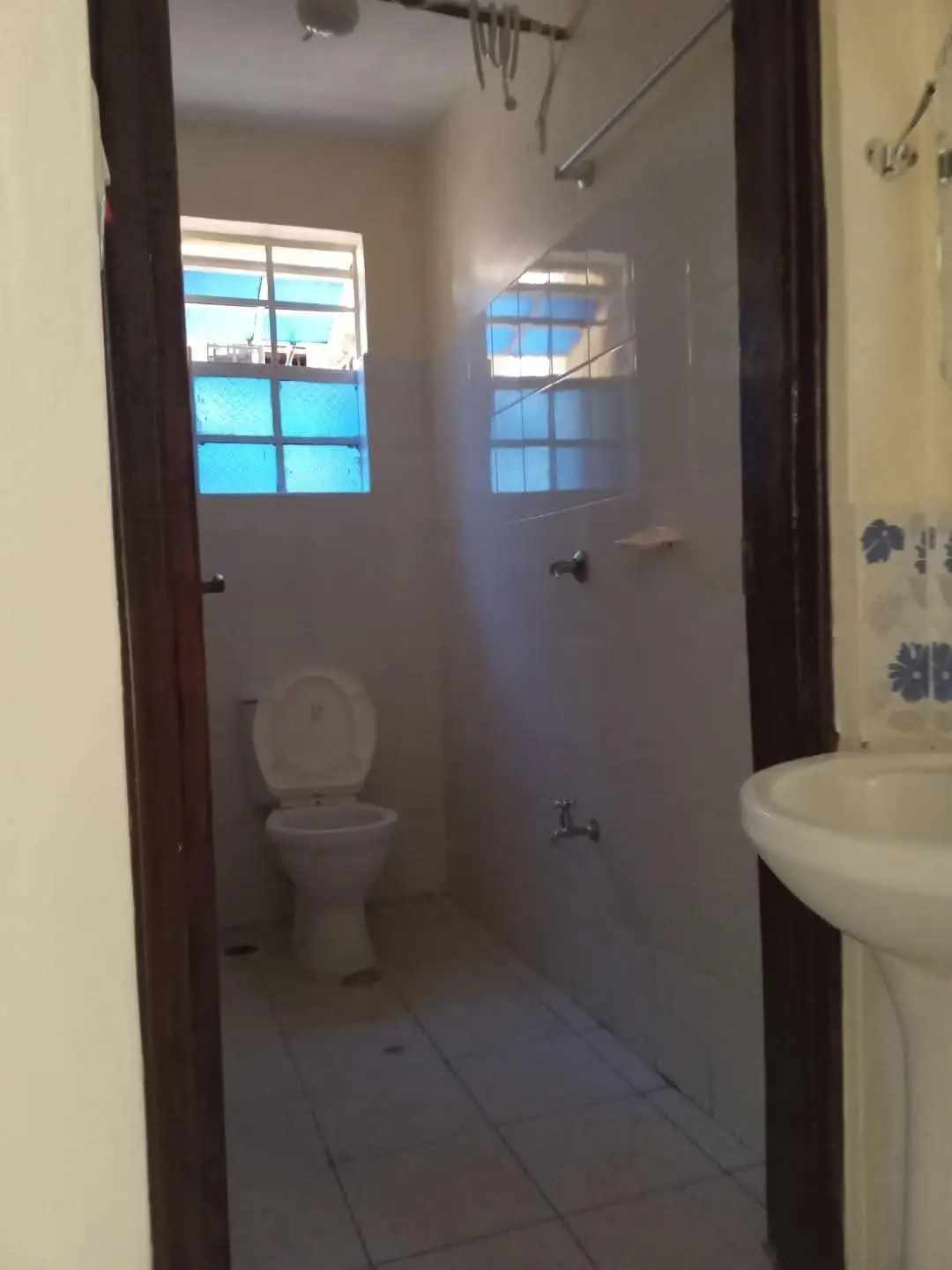 Spacious bathroom with toilet, shower enclosure, and sink