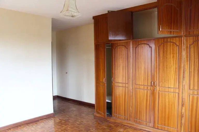 Spacious bedroom with built-in wooden wardrobe storage