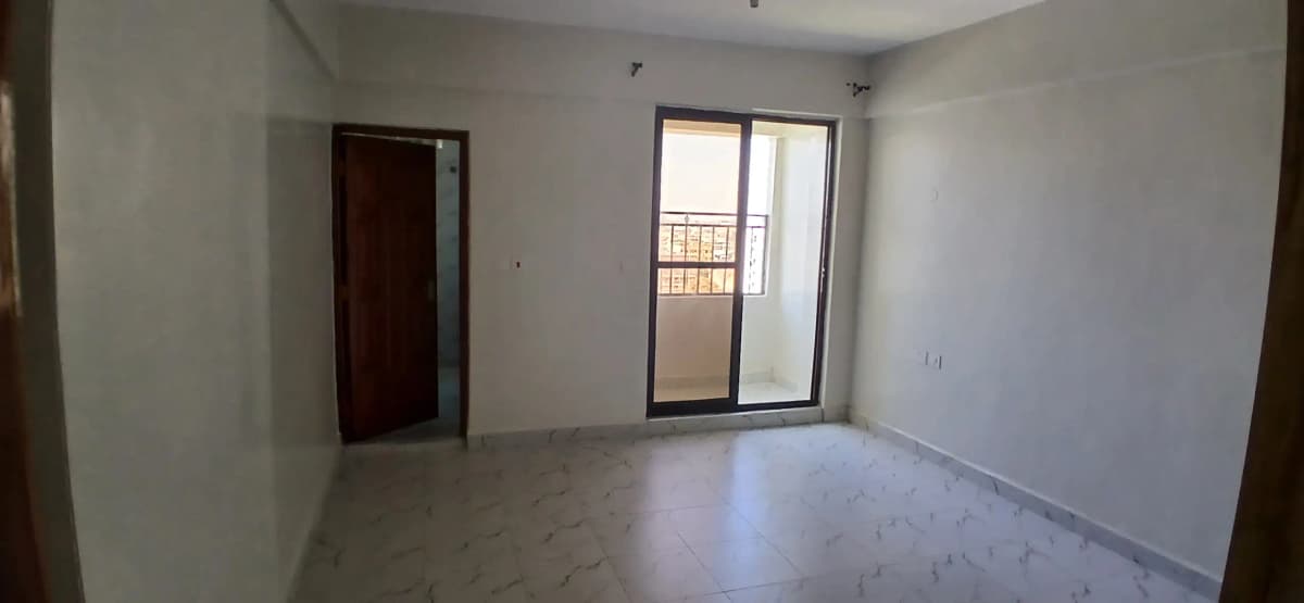 Empty living room with sliding glass doors and balcony access