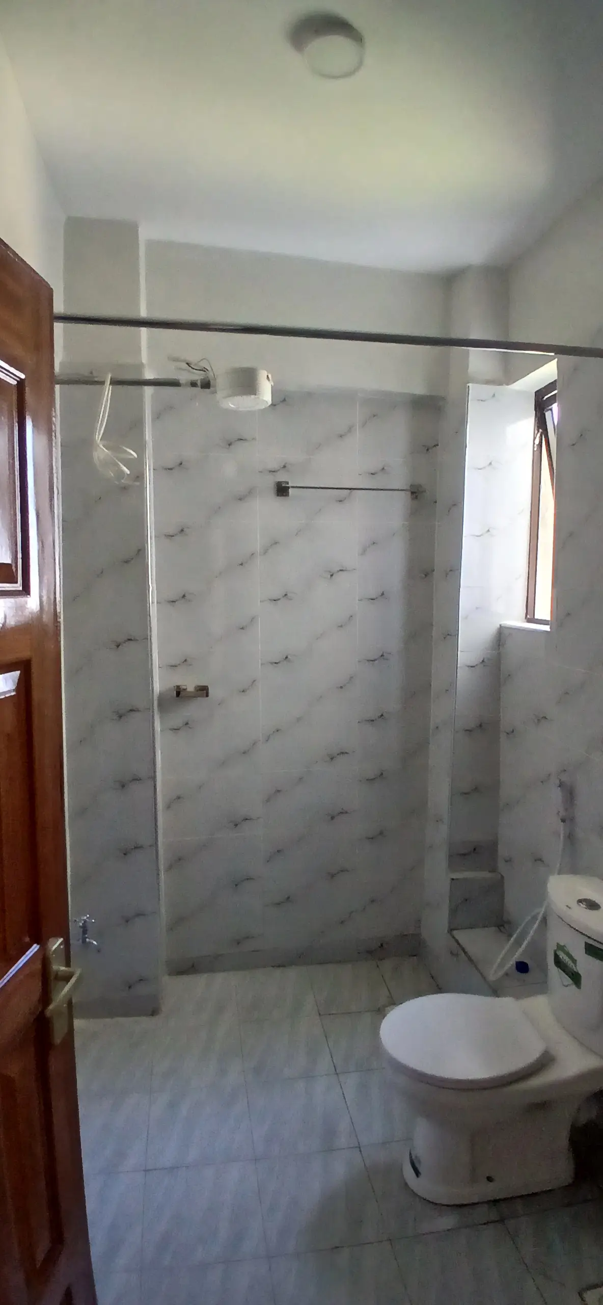 Modern bathroom with glass shower enclosure and white toilet