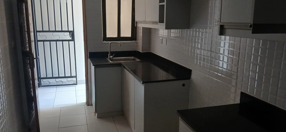 Modern kitchen with black countertops and white tile backsplash