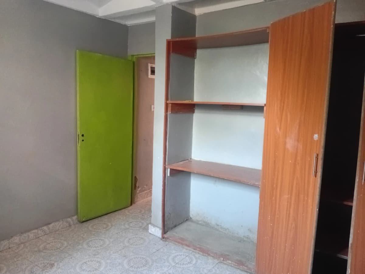 Unfurnished bedroom with built-in wooden wardrobe storage