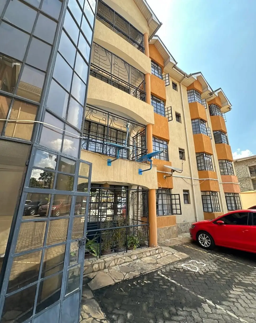 Multi-story residential building facade with parking and entrance