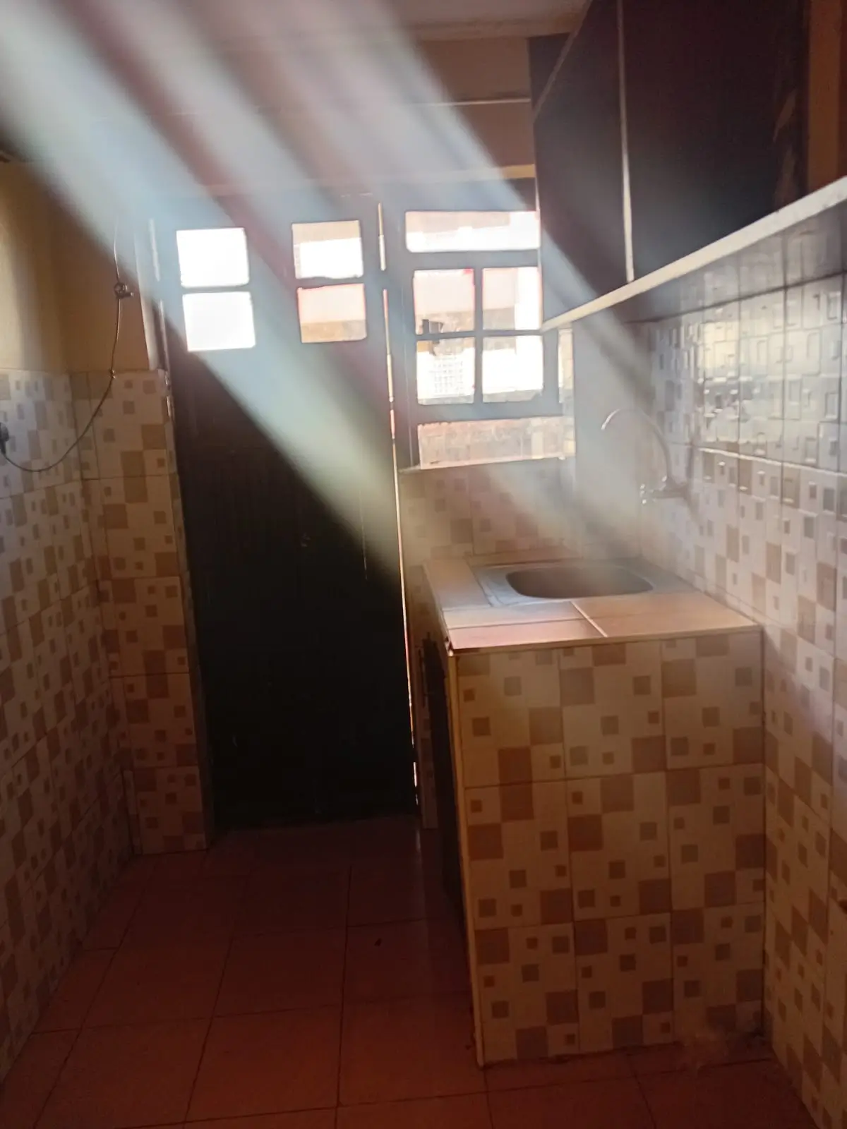 Kitchen with tiled walls and counter space, natural light