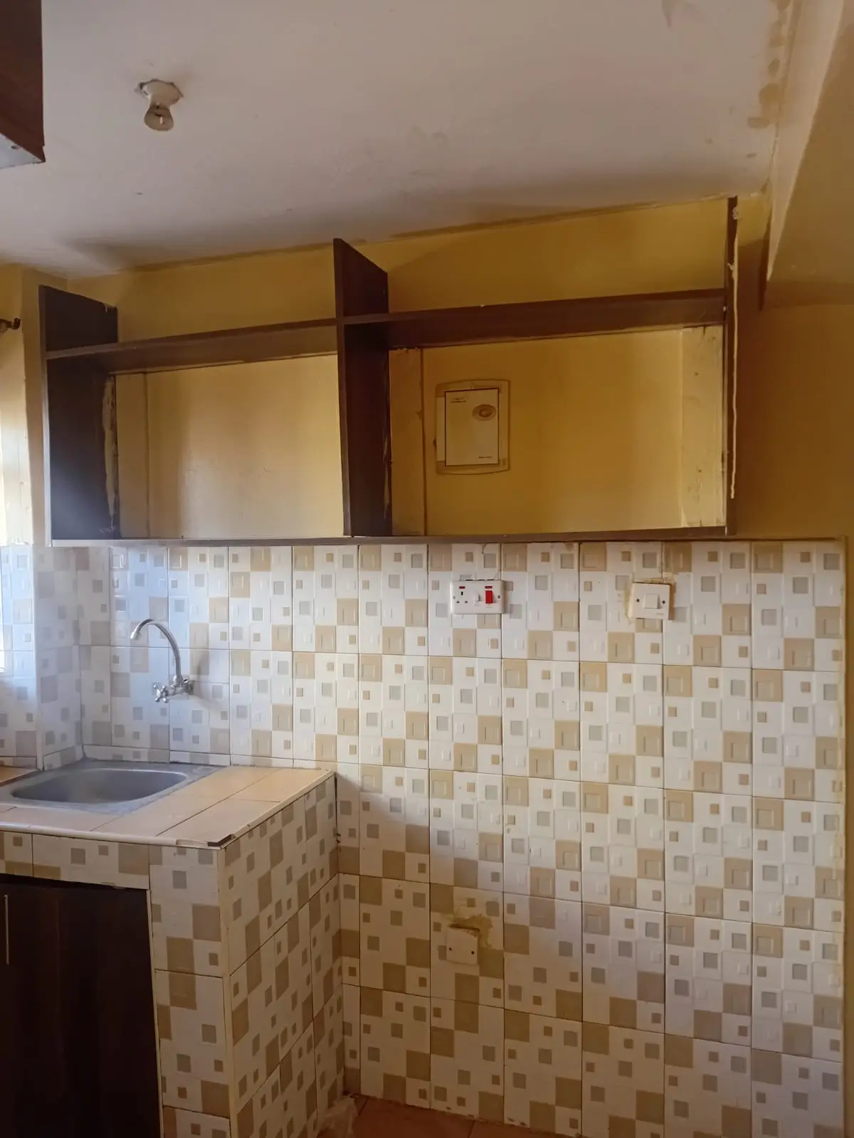 Compact kitchen with tiled backsplash and wooden cabinetry