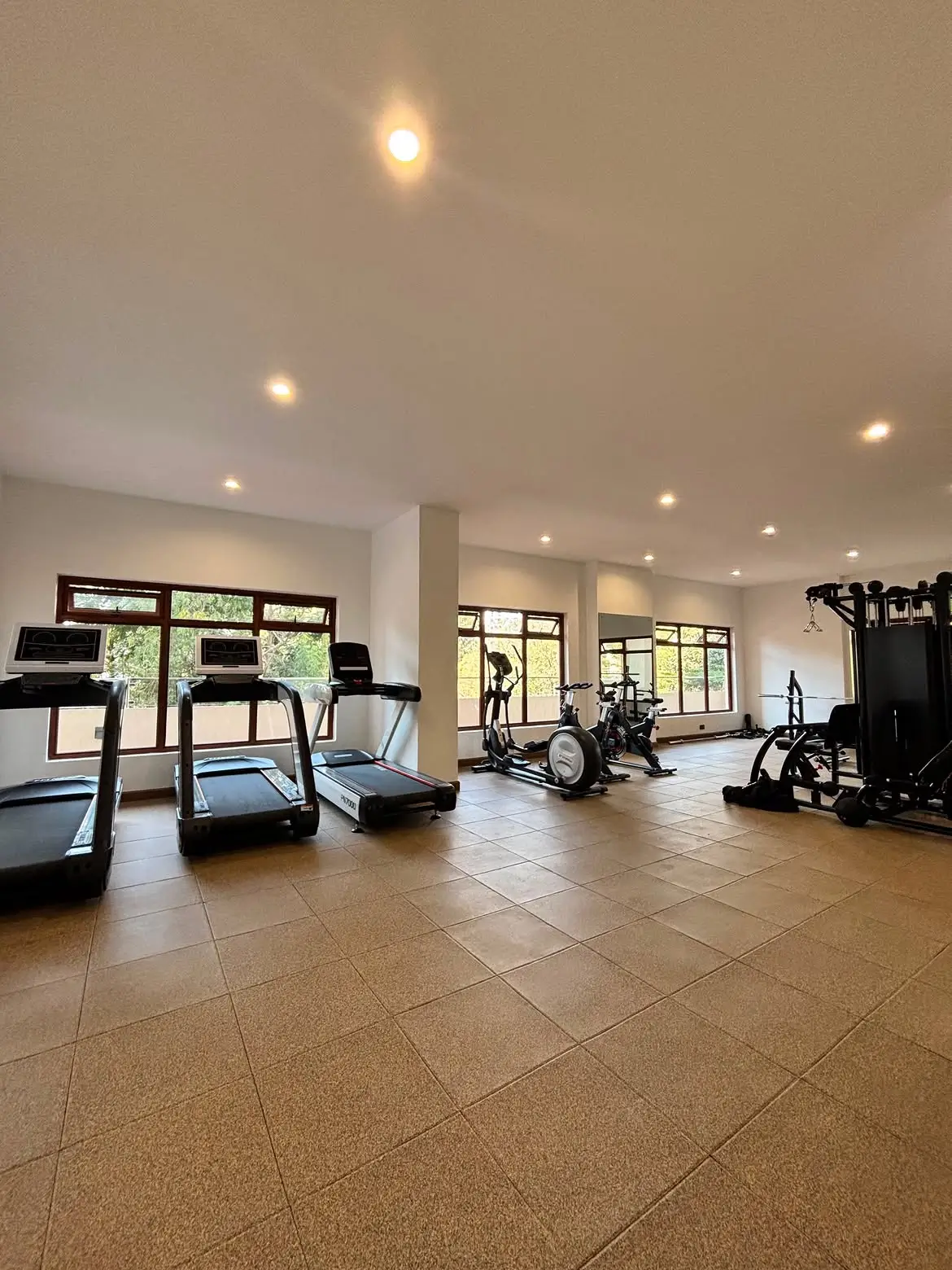 Spacious gym with treadmills, spin bikes, and cable machine
