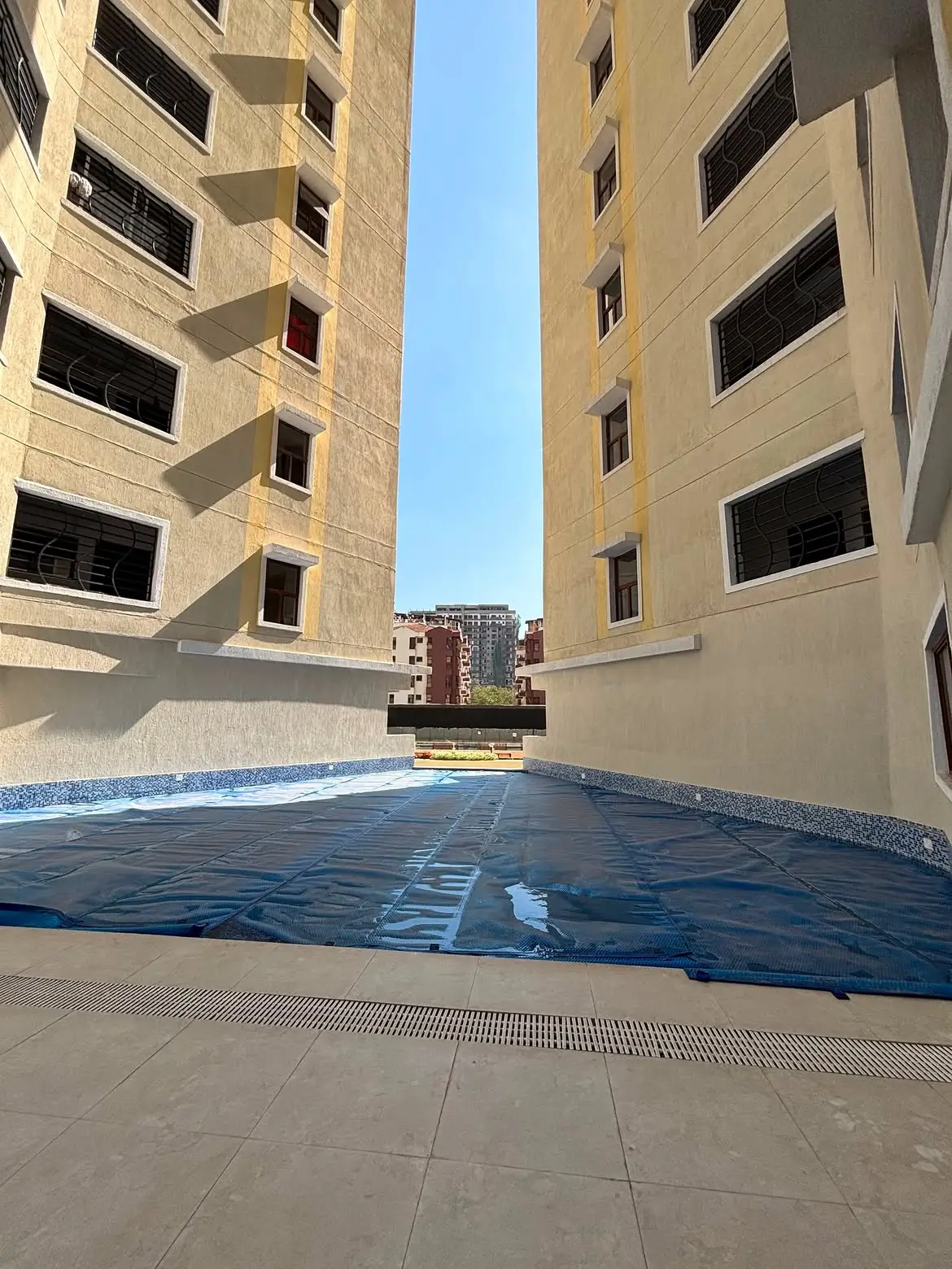 Covered swimming pool between two apartment building wings