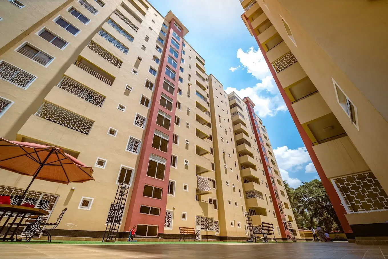 Multi-story residential building complex with red and beige facade