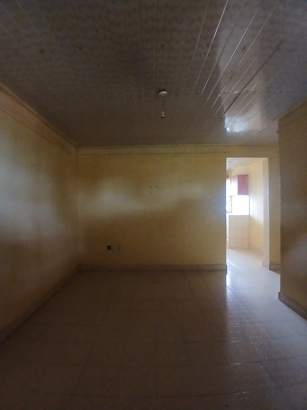 Empty living room with yellow walls and dark flooring