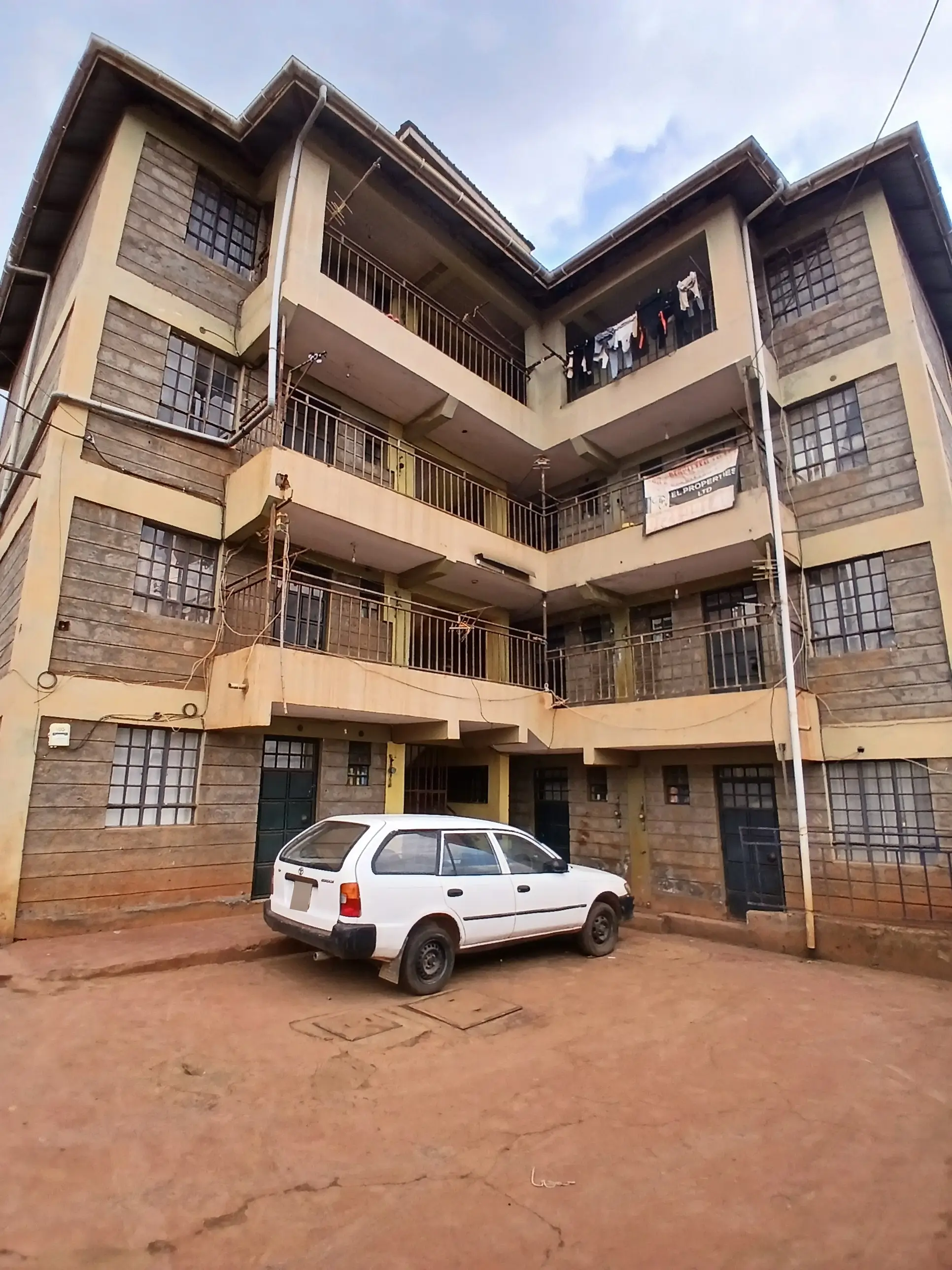 Four-story residential apartment building with central compound parking