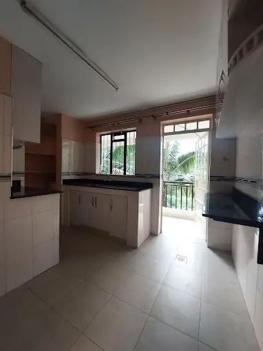Modern kitchen with island, black countertops, balcony access