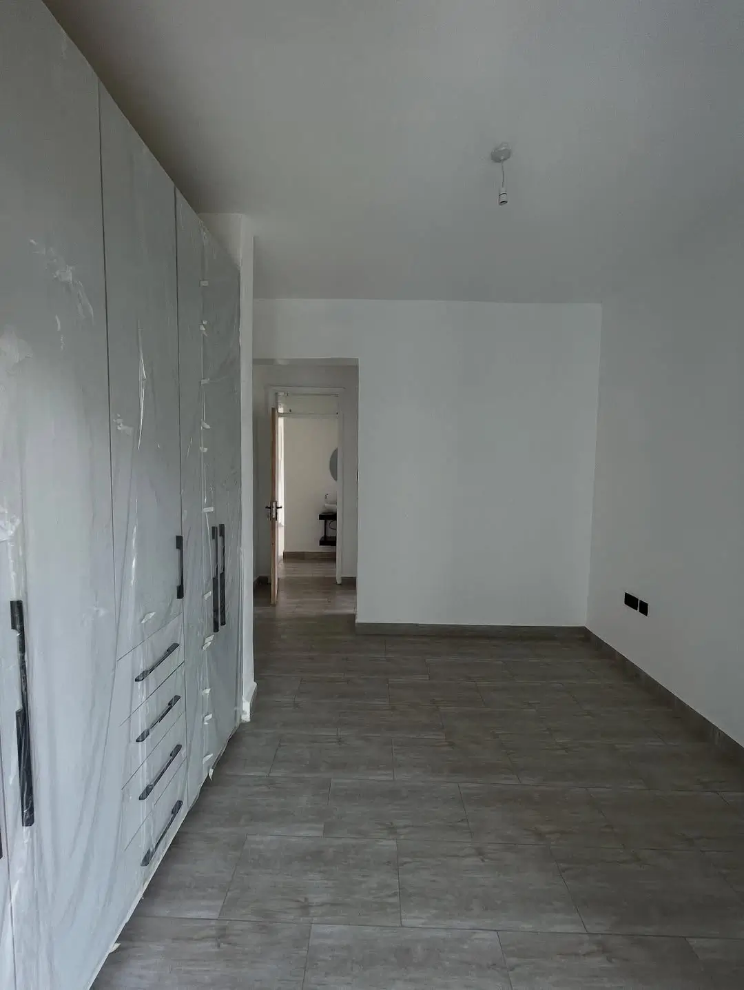 Spacious bedroom with built-in wardrobes and dark flooring