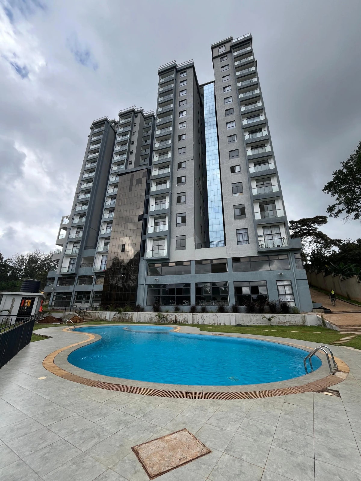 Circular blue swimming pool with modern apartment building backdrop