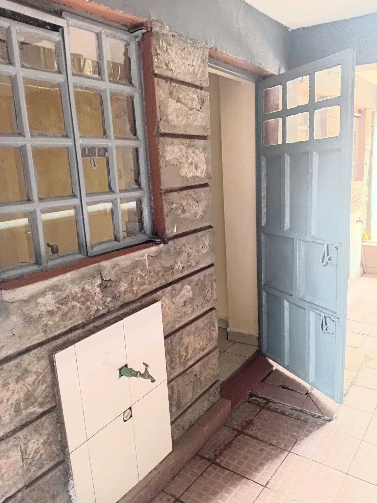 Small kitchen with brick accent wall and window cabinet storage