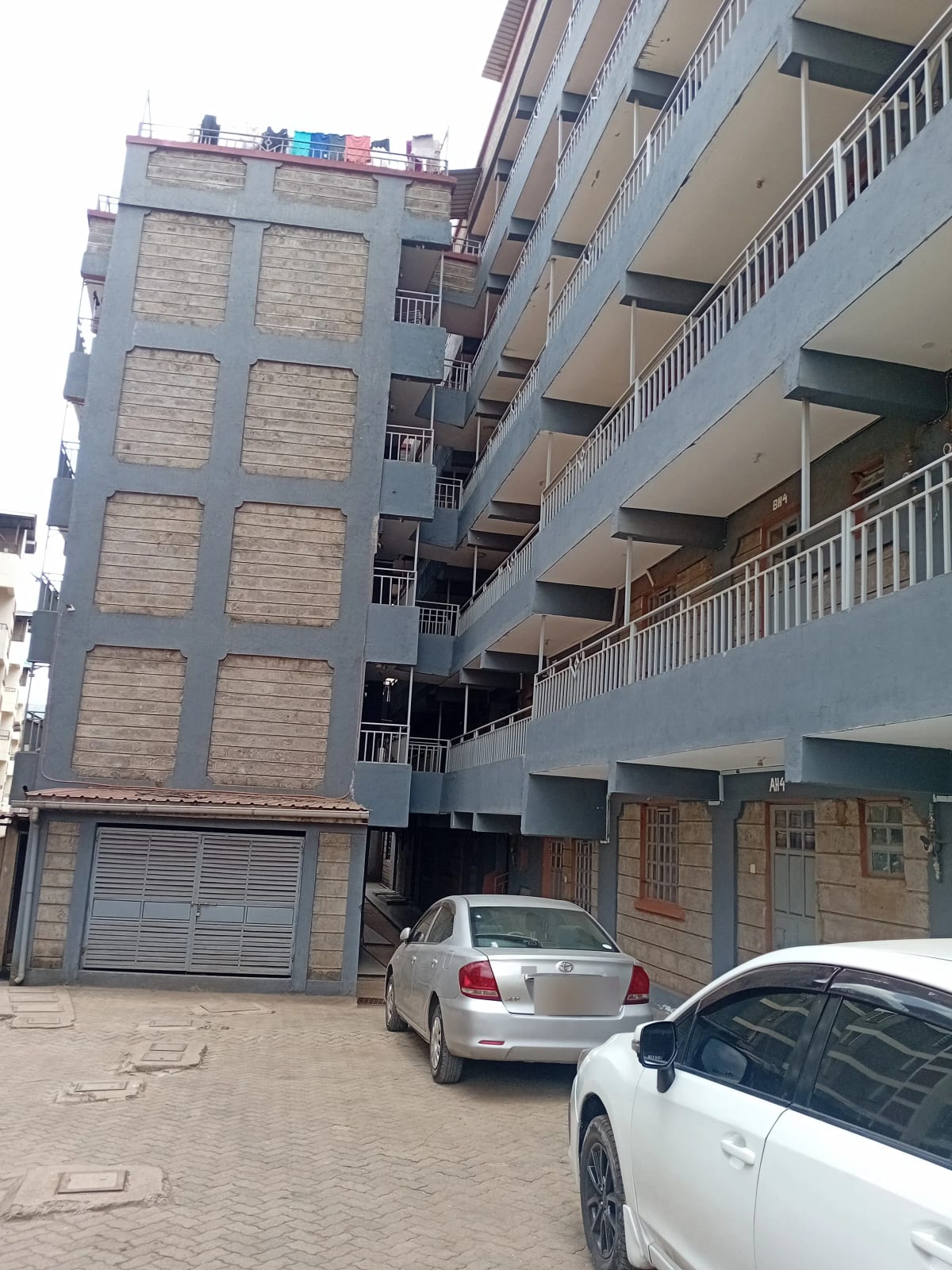 Multi-story residential building with ground-level parking bays