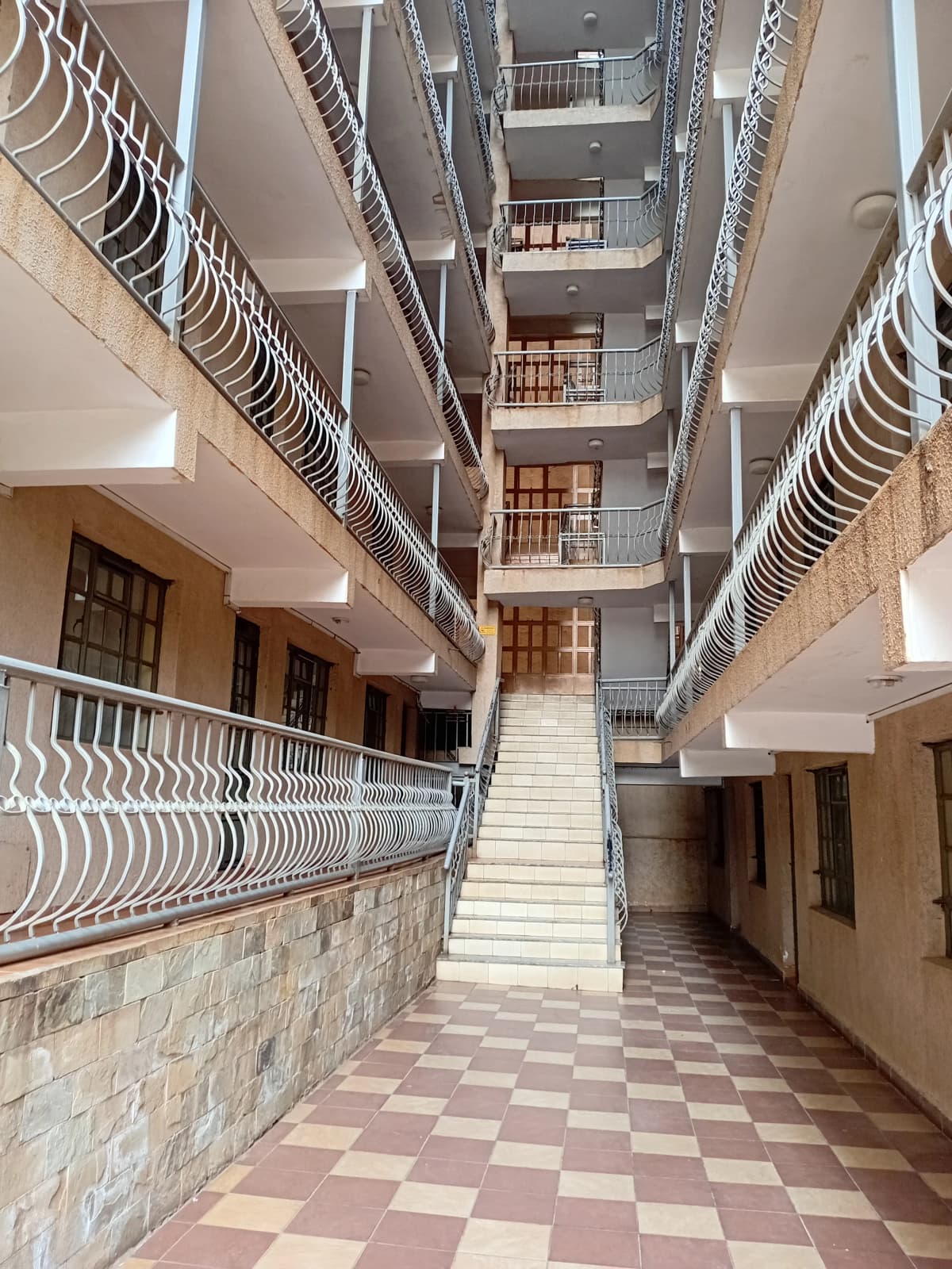 Multi-story building lobby with central staircase and balconies