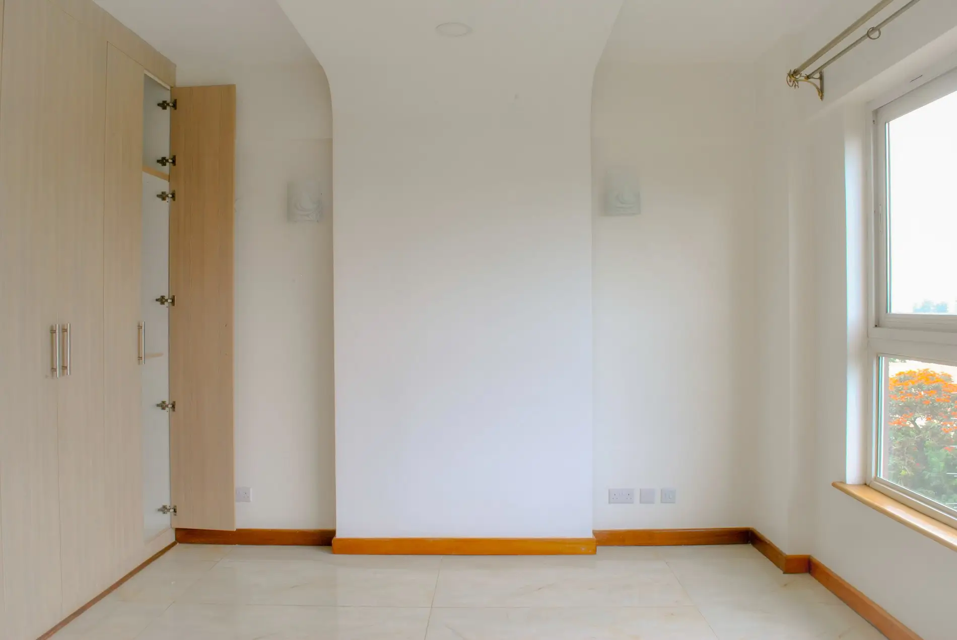 Unfurnished bedroom with white walls and wooden trim