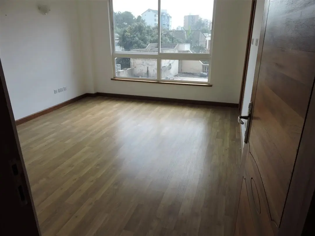 Spacious living room with wooden floors and city views