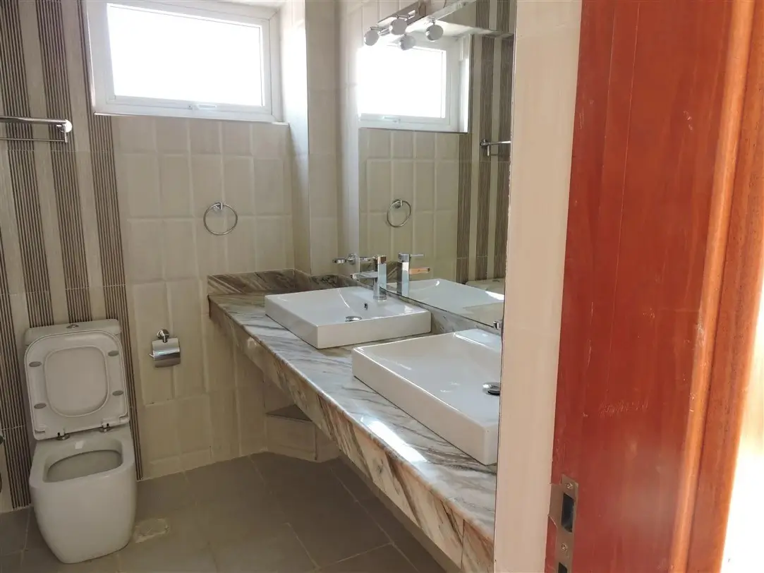 Modern bathroom with dual sink vanity and toilet
