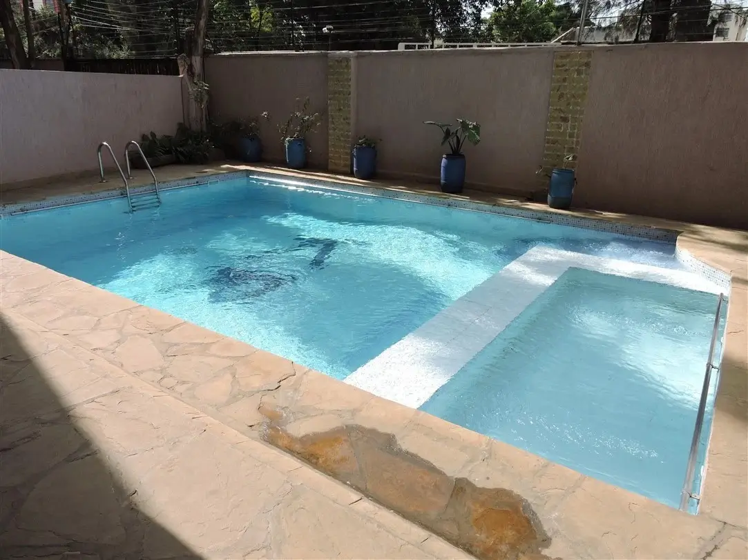 Rectangular swimming pool with spa section and concrete deck