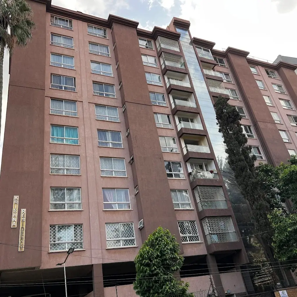 Multi-story residential building with brown facade and balconies