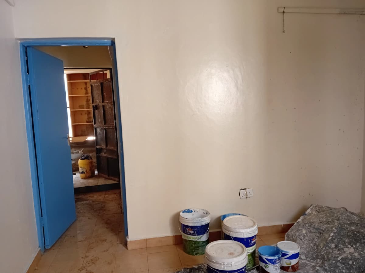 Interior space under renovation with paint supplies and blue door