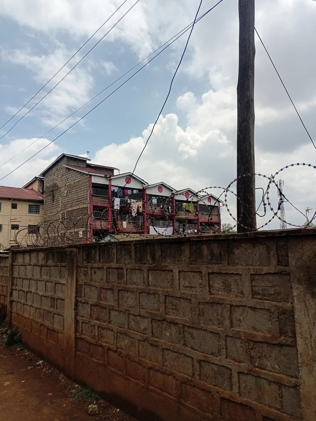 Compound perimeter wall with residential buildings beyond