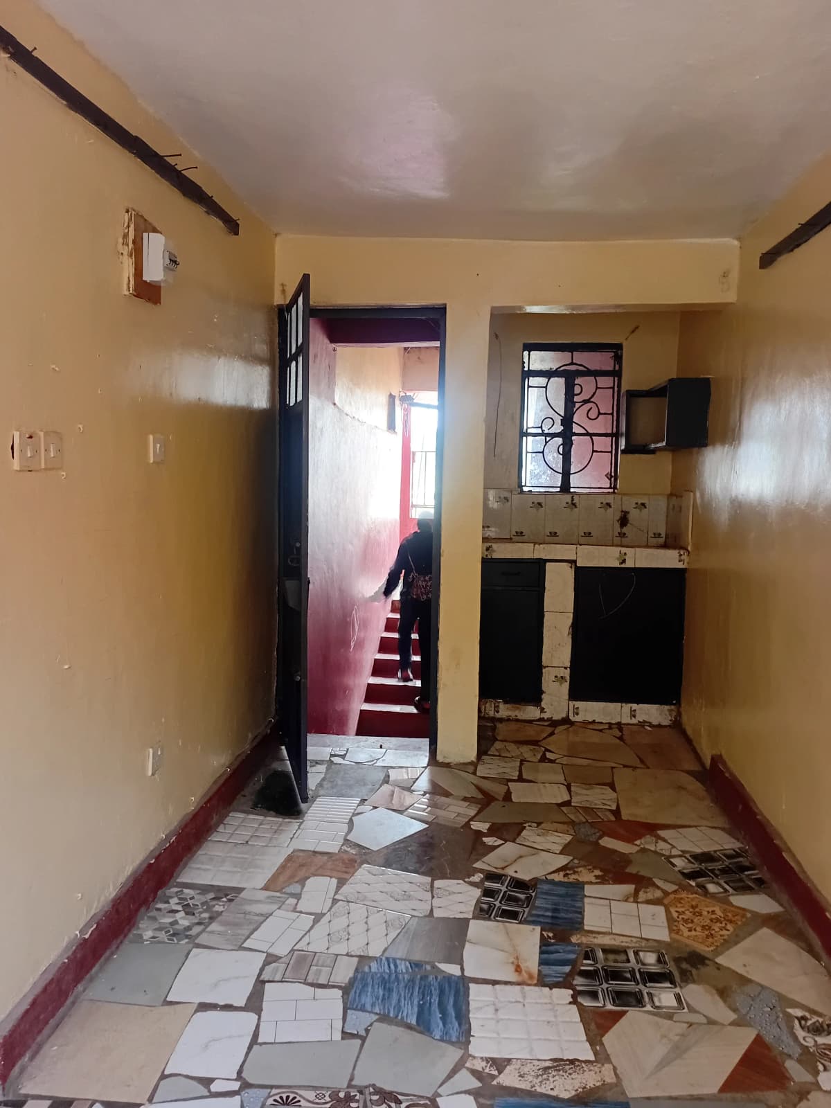 Compact kitchen with dark cabinetry and tiled flooring